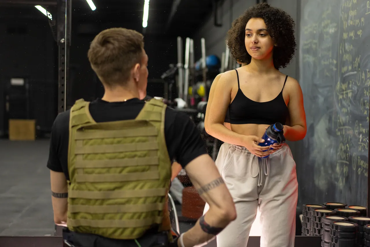 A personal trainer talking with a client in a gym