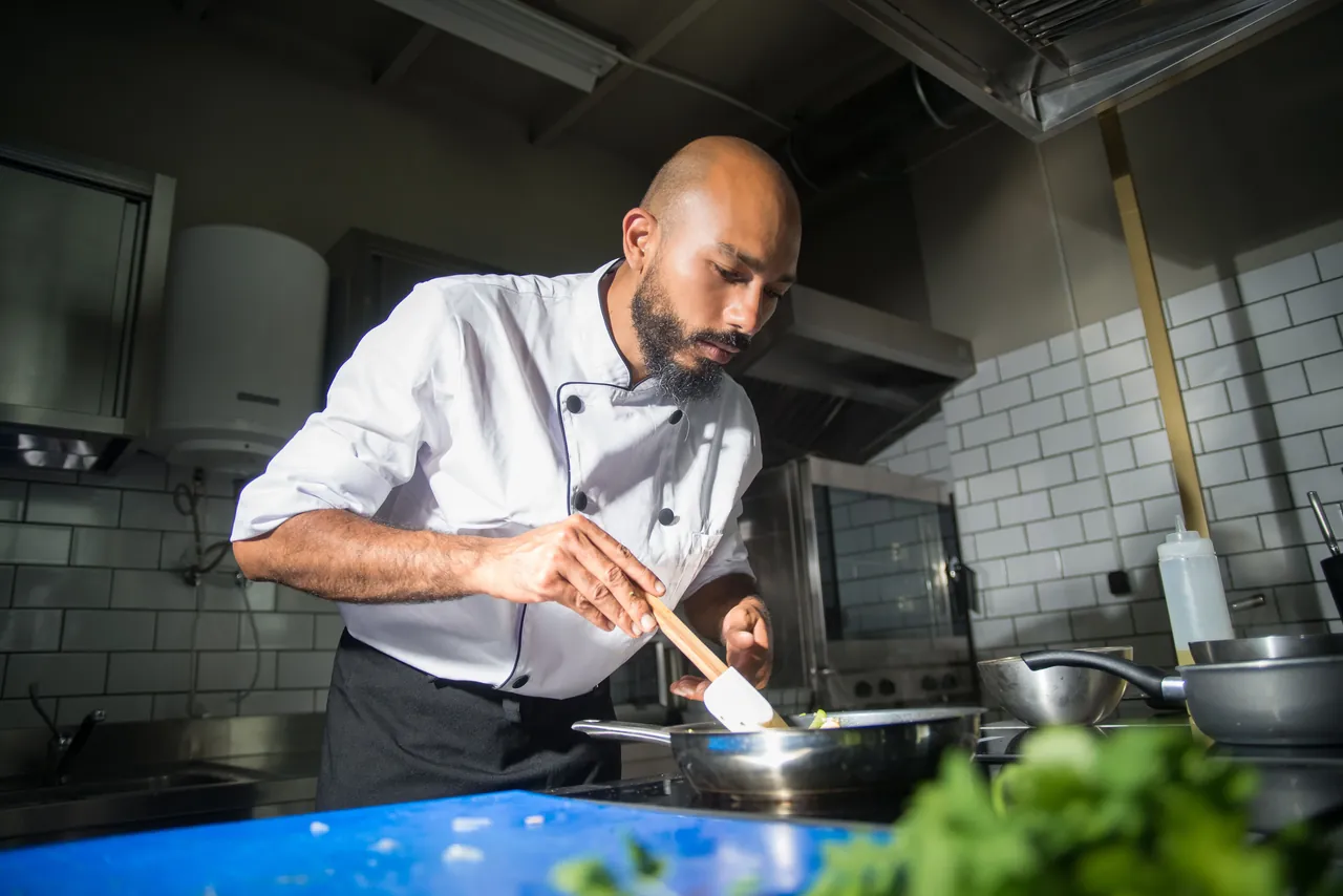 A chef plating a dish in a restaurant kitchen