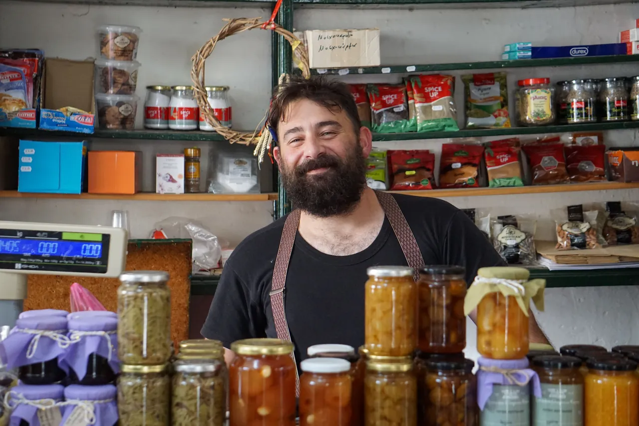 A shopkeeper standing behind shelves of homemade products